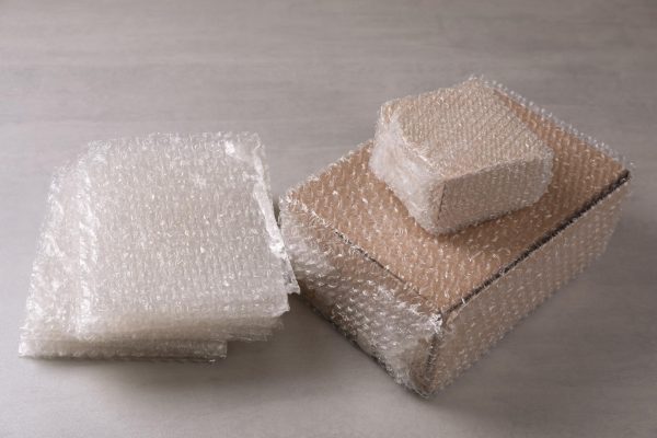 cardboard-boxes-bubble-wrap-light-grey-table_495423-45646