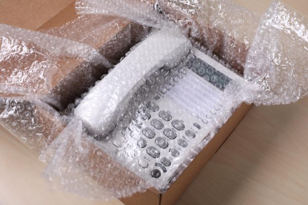 corded-phone-with-bubble-wrap-cardboard-box-wooden-table-closeup_495423-48424